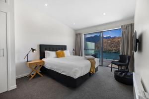 a bedroom with a bed and a large window at Remarkable Views on Goldrush in Queenstown