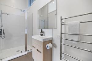 a white bathroom with a sink and a shower at Remarkable Views on Goldrush in Queenstown +19 photos