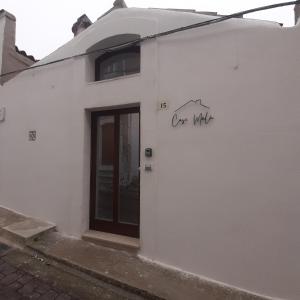 a white building with a door and the words one white at Casa MaLù 15 Cin I T 0 7 1 0 3 3 B 4 0 0 0 8 8 3 3 2 in Monte SantʼAngelo