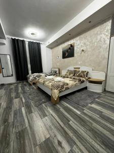 1 Schlafzimmer mit 2 Betten und Holzboden in der Unterkunft Pensiunea Old Sheriff in Bistriţa
