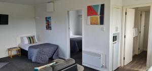 - une chambre avec un lit et un miroir dans l'établissement 554 Moana Court Motel, à Invercargill