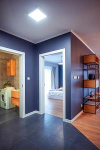 Habitación con paredes azules y dormitorio con cama. en Apartament Słoneczny en Kwidzyn