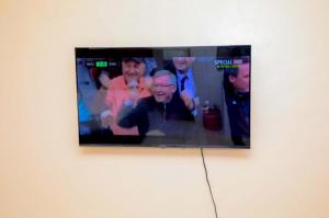 a television on a wall with a group of people at Nuri Homes in Kisii