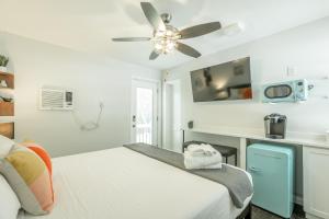 a white bedroom with a bed and a ceiling fan at 12 The Gray Room - A PMI Scenic City Vacation Rental in Chattanooga