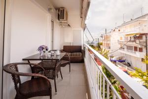 a balcony with a table and chairs on a building at Emi's beach apartment in Nea Kalikratia