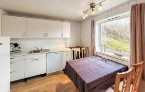 una cucina con tavolo, lavandino e finestra di Cozy Apartment In Sveio With Kitchen a Sveio