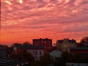 una puesta de sol sobre una ciudad con casas y edificios en Apartament Słoneczny en Kwidzyn