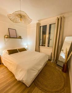 - une chambre avec un lit blanc et une grande fenêtre dans l'établissement Appartement cosy au coeur de Reims, à Reims