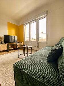 - un salon avec un lit et une télévision dans l'établissement Appartement cosy au coeur de Reims, à Reims