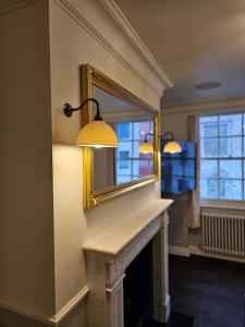 a living room with a mirror and a fireplace at Elegant 3 Bed Flat in Marylebone, London in London