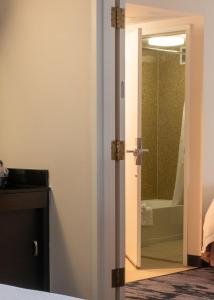 een badkamer met een deur naar een bad bij Fairfield Inn & Suites Anaheim North Buena Park in Buena Park