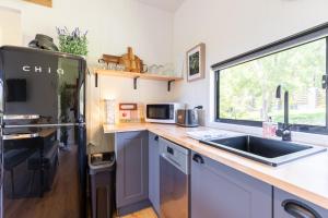 a kitchen with a sink and a refrigerator at Woodmans Cottage 24, Gold Coast Hinterland in Wongawallan