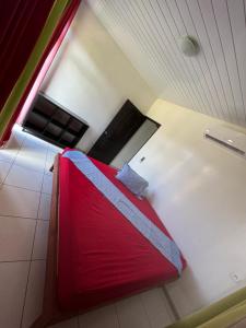 a bedroom with a red bed in a room at Taiohae Bay in Nuku Hiva