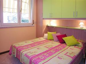 a bedroom with a large bed with colorful pillows at Appartamenti Paola in Bibione