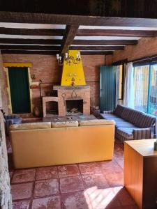 - un salon avec un canapé et une cheminée dans l'établissement Sitio Ramalhete - Sua escapada perfeita na Serra da Mantiqueira, à São Bento do Sapucaí