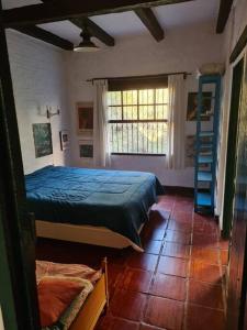 a bedroom with a bed with a blue comforter at Sitio Ramalhete - Sua escapada perfeita na Serra da Mantiqueira in São Bento do Sapucaí