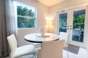 a dining room with a table and white chairs at Wilton Manors Cottage West 2 Bed 2 Bath With Pool in Fort Lauderdale