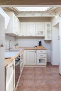 a kitchen with white cabinets and a tile floor at White Attic Lucca in Lucca
