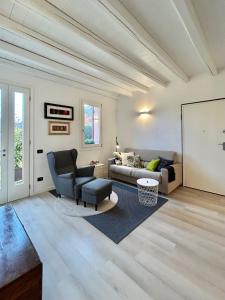 ein Wohnzimmer mit einem Sofa und einem Stuhl in der Unterkunft Soranza Suite in Castelfranco Veneto