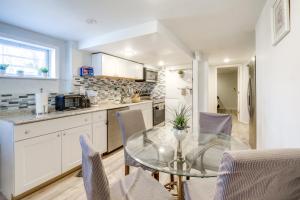 a kitchen with a glass table and chairs at Oxon Hill Rental about 3 miles to MGM National Harbor in Oxon Hill