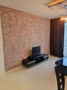 a living room with a tv on a wall at Apartament BEACH VIBES Nessebar in Nesebar