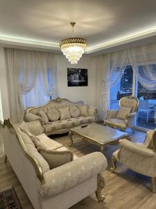 a living room with couches and a chandelier at Royal Villa in Forest in Dosemealti