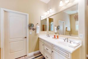 une salle de bain avec un lavabo et un grand miroir dans l'établissement Desert Blossom, à Liberty 15 autres photos