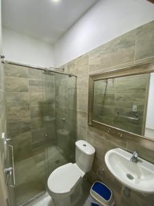 een badkamer met een toilet, een wastafel en een douche bij Encanto Apartahotel in Santa Marta