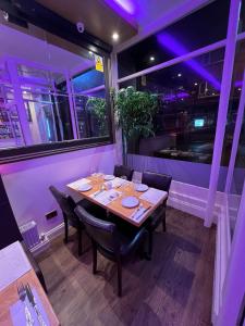 a dining table in a restaurant with purple lights at ABBEY HOLIDAY ACCOMMODATiON in Whitby +70 photos