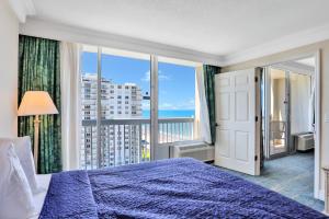 a bedroom with a blue bed and a large window at Daytona Beach Resort 1216 in Daytona Beach