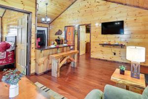 a living room with wooden walls and a tv in a cabin at Cabin with Expansive Deck about 4 Mi to Red River Gorge! in Rogers