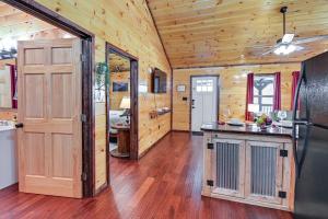 a kitchen with wooden walls and a wooden floor at Cabin with Expansive Deck about 4 Mi to Red River Gorge! in Rogers