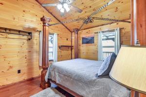ein Schlafzimmer mit einem Bett in einem Blockhaus in der Unterkunft Cabin with Expansive Deck about 4 Mi to Red River Gorge! in Rogers