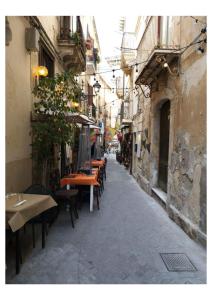 an empty street with tables and chairs in an alley at Casa Angelino in Siracusa +46 photos