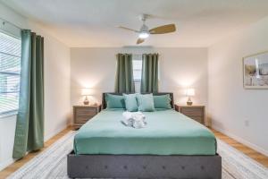um quarto com uma grande cama verde e uma ventoinha em Home with Screened Porch, Near Weeki Wachee Springs! em Spring Hill