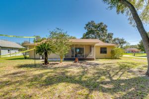 a house with a palm tree in the yard at Home with Screened Porch, Near Weeki Wachee Springs! in Spring Hill