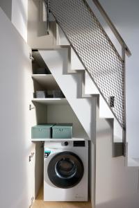 uma lavandaria com uma máquina de lavar e secar roupa debaixo das escadas em 21 Stylish Lofts by Dream Stay em Talin