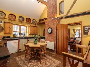 a kitchen with a table and a brick wall at The Granary in Shrewsbury