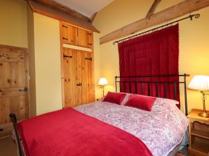 una camera con letto rosso e tenda rossa di The Old Dairy a Shrewsbury