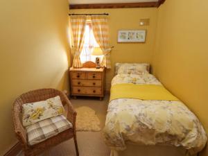 una camera da letto con un letto, una sedia e una finestra di The Old Dairy a Shrewsbury