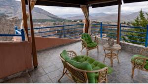 a balcony with a bed and chairs and a table at Xristina's sofita in Kozani