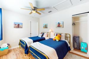 ein Schlafzimmer mit zwei Betten und einem Deckenventilator in der Unterkunft Coastal Cottage in Bradenton + 17 Fotos