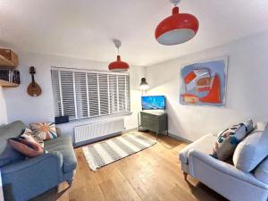 Sala de estar con 2 sofás y TV en Bungalow, mountain and sea views parking, en Aberdyfi