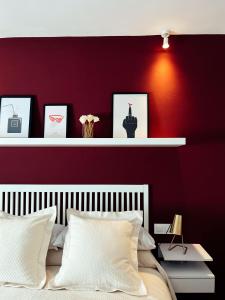 1 dormitorio con pared roja y cama blanca en María Luisa Home en Priego de Córdoba