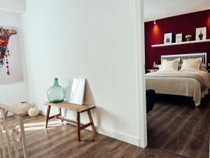 um quarto com uma cama com uma parede vermelha em María Luisa Home em Priego de Córdoba