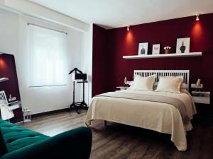 1 dormitorio con 1 cama grande y paredes rojas en María Luisa Home en Priego de Córdoba