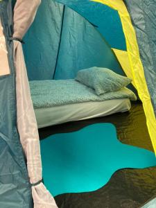 a green and yellow tent with a pillow in it at Indoor Camping Helsinki in Helsinki