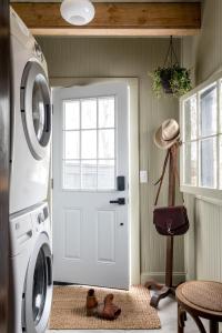a laundry room with a white door and a washing machine at Bespoke 1920's Charm, Walk 2 Warren, & Hot Tub - The Spring House in Hudson