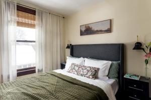 a bedroom with a large bed and a window at Bespoke 1920's Charm, Walk 2 Warren, & Hot Tub - The Spring House in Hudson