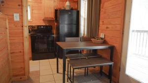a kitchen with a black refrigerator and a table at The Cave at Shady Woods - 1 Bedroom Studio - Walk to Downtown! in Gatlinburg